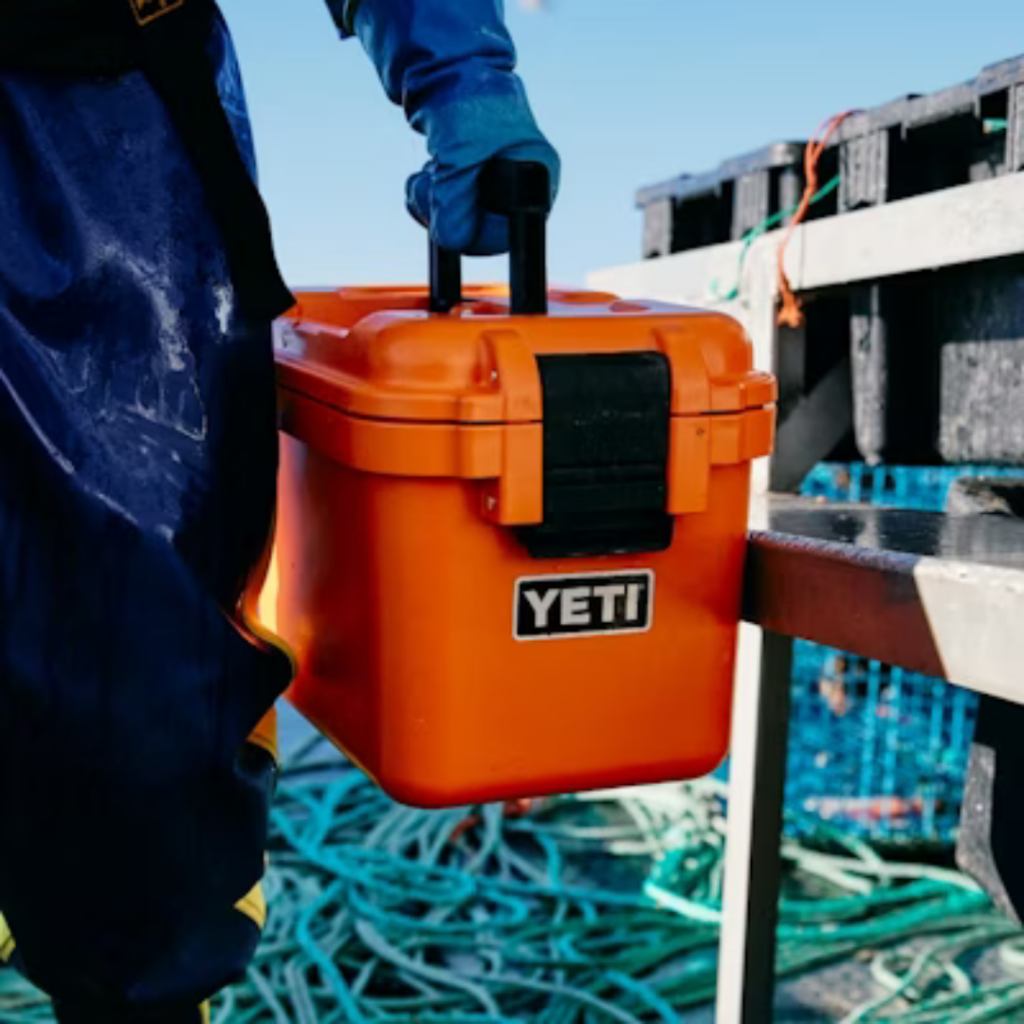 Close up of a YETI gear box, held by a person with tools in the background.